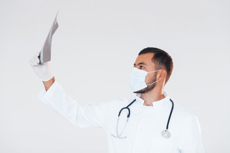 Medic with x-ray. Young handsome man standing indoors against white backgroundの写真素材