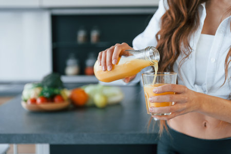 Young european woman is indoors at kitchen indoors with healthy foodの写真素材