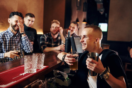 Expressive people watching soccer. Group of people together indoors in the pub have fun at weekend timeの写真素材