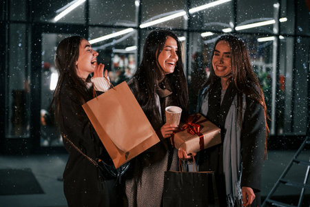 After shopping. Three cheerful women spends Christmas holidays together outdoors. Conception of new yearの写真素材