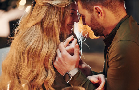 Closeness of the people. Young lovely couple have romantic dinner indoors togetherの写真素材