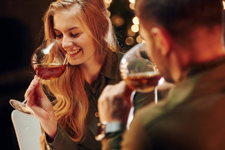 Tasting wine. Young lovely couple have romantic dinner indoors together