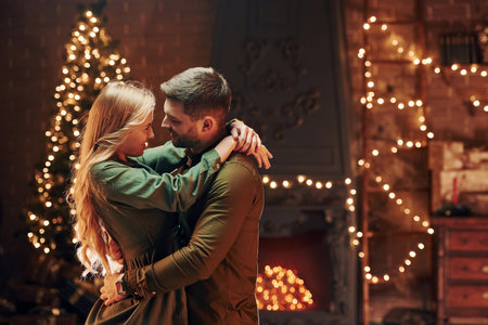 Standing and embracing each other. Young lovely couple have romantic dinner indoors togetherの写真素材