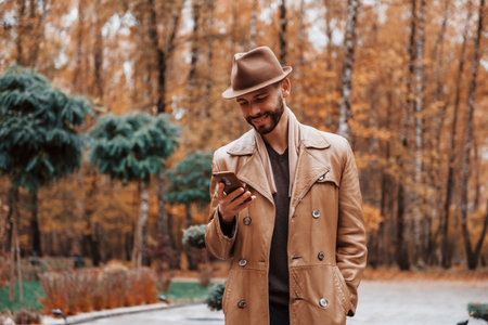 Young male model in fashionable clothes is outdoors in the park at daytimeの写真素材