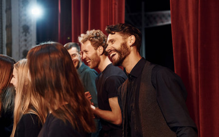 Working together. Group of actors in dark colored clothes on rehearsal in the theater
