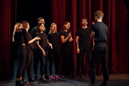 Group of actors in dark colored clothes on rehearsal in the theaterの写真素材