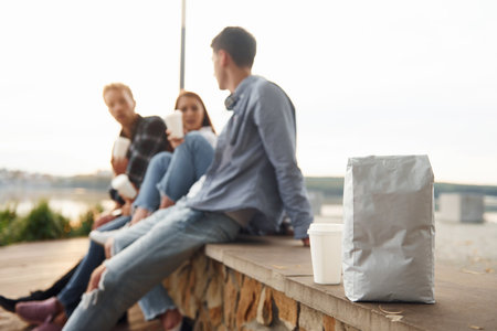 Coffee package. Group of young cheerful friends that is outdoors having fun togetherの写真素材