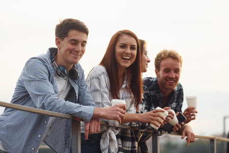 Coffee time. Group of young cheerful friends that is outdoors having fun together