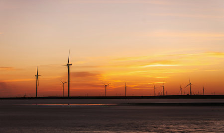 Orange sky. Many of windmills on the Jarilgach island, Ukraine. Sunset time