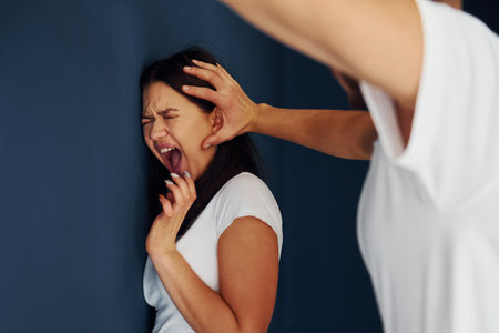 Violent aggressive young man beats his girlfriend at homeの写真素材