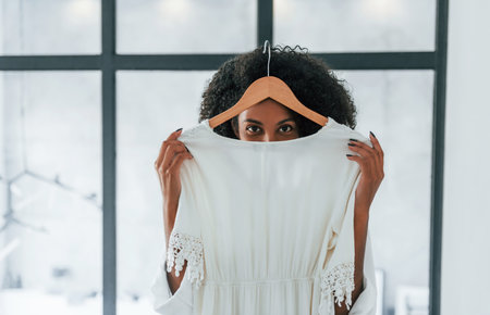 With different clothes. Young african american woman with curly hair indoors at homeの写真素材