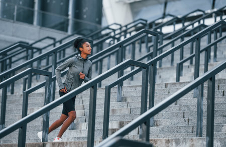 Active runner. Young african american woman in sportive clothes have workout outdoors at daytimeの写真素材