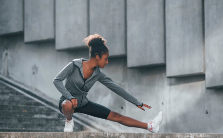 Conception of sport. Young african american woman in sportive clothes have workout outdoors at daytimeの写真素材