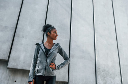 Young african american woman in sportive clothes have workout outdoors at daytimeの写真素材