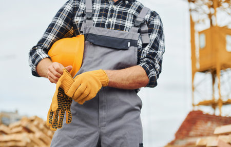 Takes a break. Construction worker in uniform and safety equipment have job on buildingの写真素材