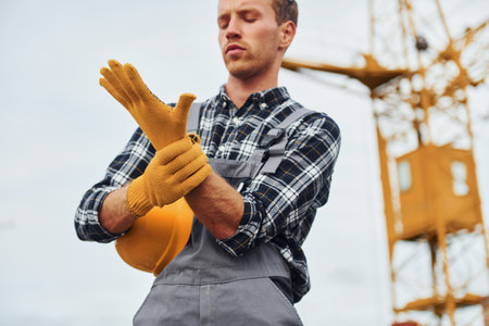 Takes a break. Construction worker in uniform and safety equipment have job on buildingの写真素材