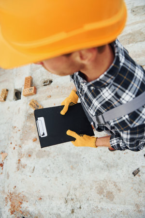 Top close up view of construction worker in uniform and safety equipment that have job on buildingの写真素材