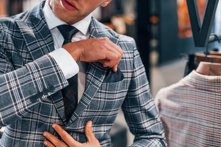 In jacket with tie. Young guy in modern store with new clothes. Elegant expensive wear for menの写真素材