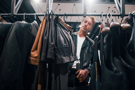 Weekend shopping. Young guy in modern store with new clothes. Elegant expensive wear for menの写真素材