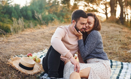 On picnic. Cheerful lovely young couple having a rest outdoors togetherの写真素材