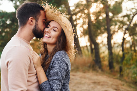Standing and hugging. Cheerful lovely young couple having a rest outdoors togetherの写真素材