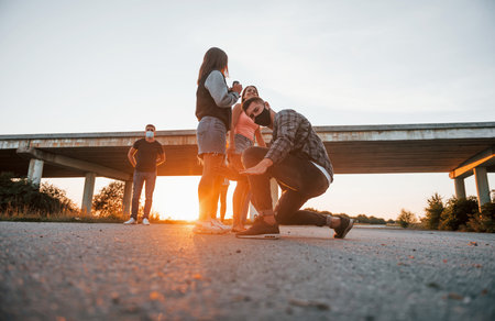 Walking on the road. Group of young cheerful friends having fun together. Party outdoorsの写真素材