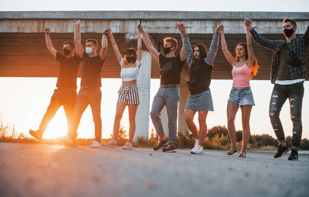 Embracing each other. Group of young cheerful friends having fun together. Party outdoorsの写真素材