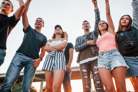 Posing for a camera. Group of young cheerful friends having fun together. Party outdoors