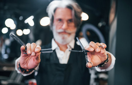 In barbershop. Stylish modern senior man with gray hair and beard is indoorsの写真素材