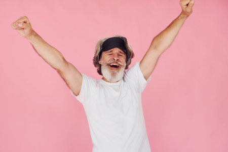 With sleep mask. Waking up. Stylish modern senior man with gray hair and beard is indoorsの写真素材