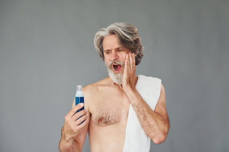 Fresh and clean face. Stylish modern senior man with gray hair and beard is indoorsの写真素材