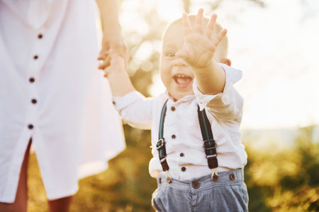 Young mother with her little son is outdoors in the forest. Beautiful sunshineの写真素材