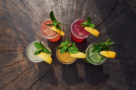Yellow and green colored. Close up view of fresh summer alcoholic cocktails on the wooden table