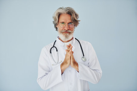 Professional positive doctor. Senior stylish modern man with grey hair and beard indoorsの写真素材