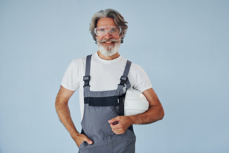 Repairman ready for work. Senior stylish modern man with grey hair and beard indoorsの写真素材