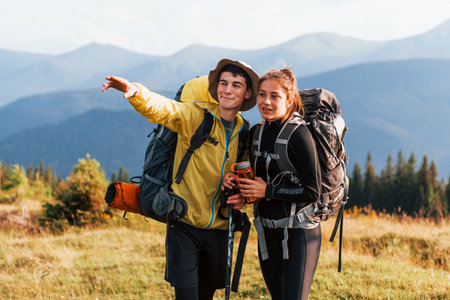 In adventure together. Cute couple. Majestic Carpathian Mountains. Beautiful landscape of untouched...