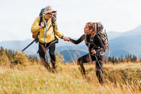 In adventure together. Cute couple. Majestic Carpathian Mountains. Beautiful landscape of untouched natureの写真素材