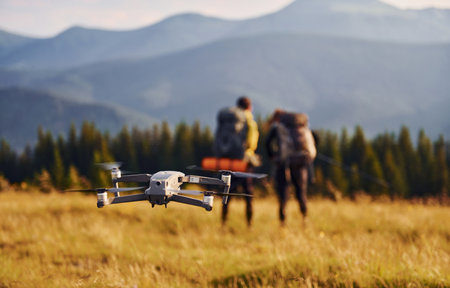 Drone flying near young travelers. Majestic Carpathian Mountains. Beautiful landscape of untouched natureの写真素材
