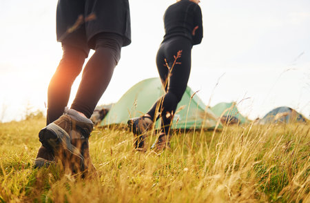 Couple having a walk outdoors near green tent. Conception of travelingの写真素材