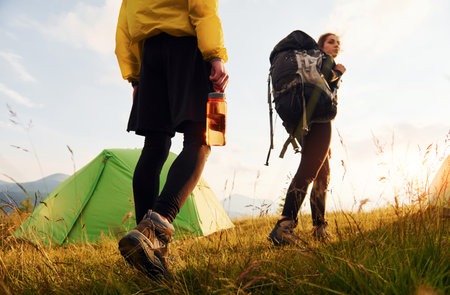 Couple having a walk outdoors near green tent. Conception of travelingの写真素材
