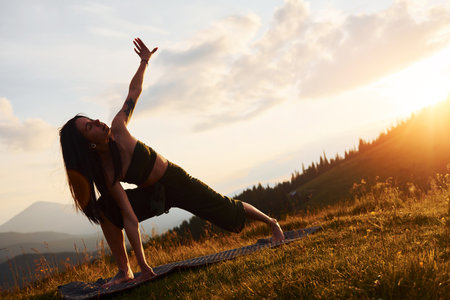 Doing yoga outdoors. Beautiful woman. Majestic Carpathian Mountains. Beautiful landscape of untouched natureの写真素材
