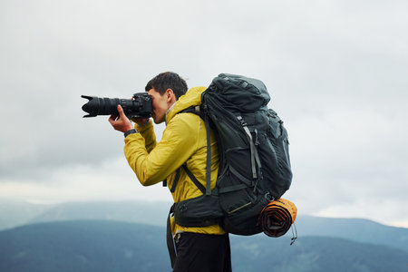 Young photographer makes photos. Majestic Carpathian Mountains. Beautiful landscape of untouched natureの写真素材