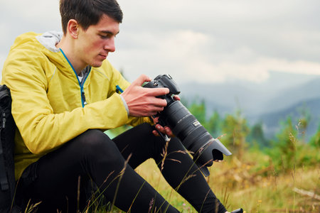 Young photographer makes photos. Majestic Carpathian Mountains. Beautiful landscape of untouched natureの写真素材