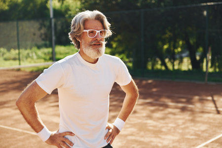 Senior modern stylish man in sunglasses outdoors on the sportive field at daytimeの写真素材