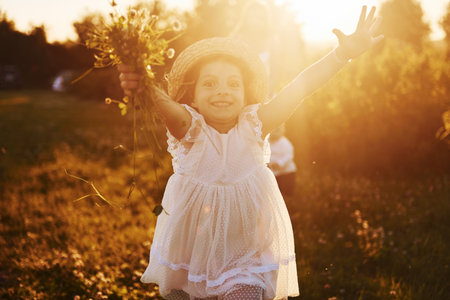 Beautiful lightbeam. Mother with boy and girl spending free time on the field at sunny day time of summerの写真素材