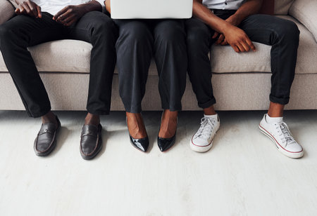 Comfortable sofa. Using laptop. Group of african american business people working when sitting togetherの写真素材