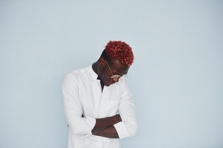 Young african american man in white formal clothes standing against wall indoorsの写真素材