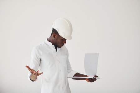 Young african american man in formal clothes indoors with laptop in handsの写真素材