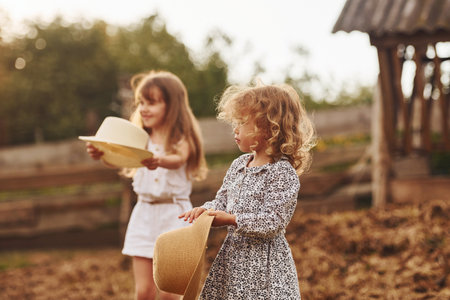 Two little girls together on the farm at summertime having weekendの写真素材