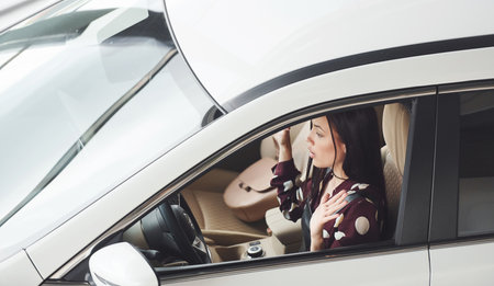 Side view of beautiful young brunette that inside of modern automobile. Riding carの写真素材